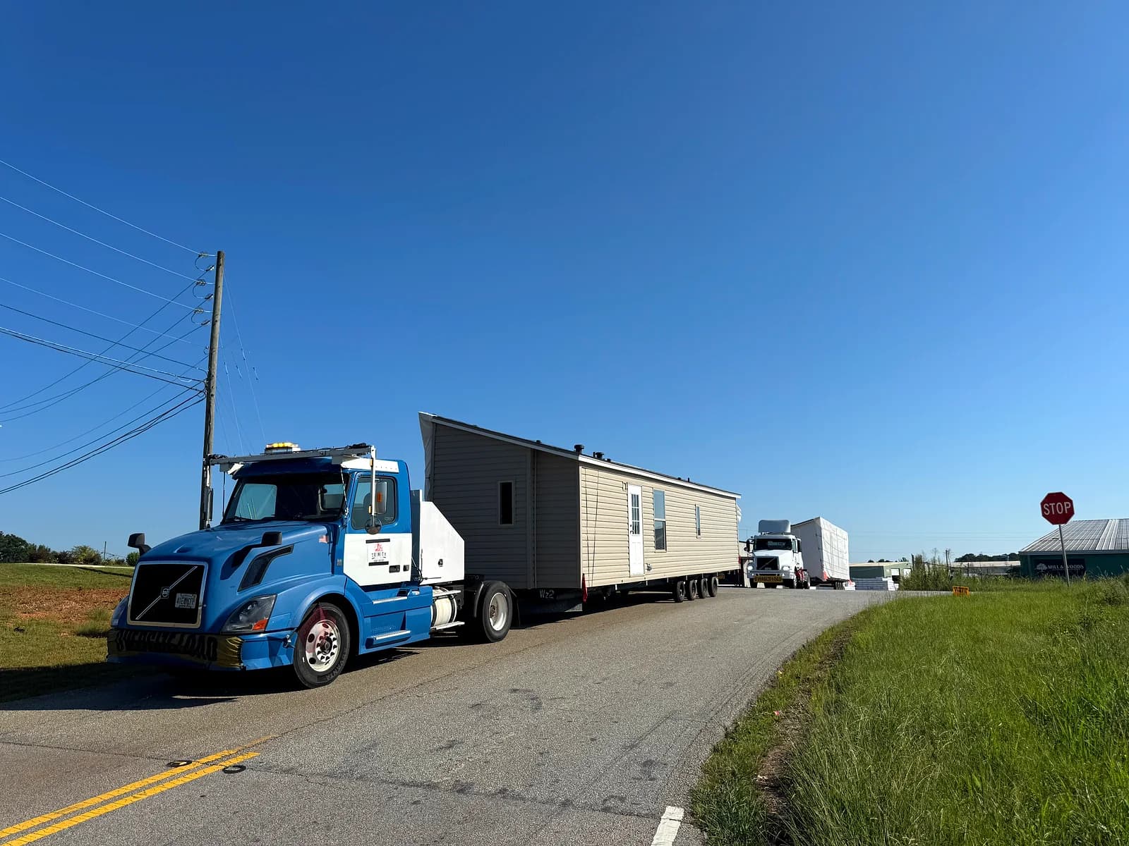 Trinity blue Volvo on a Florida road transporting a mobile home