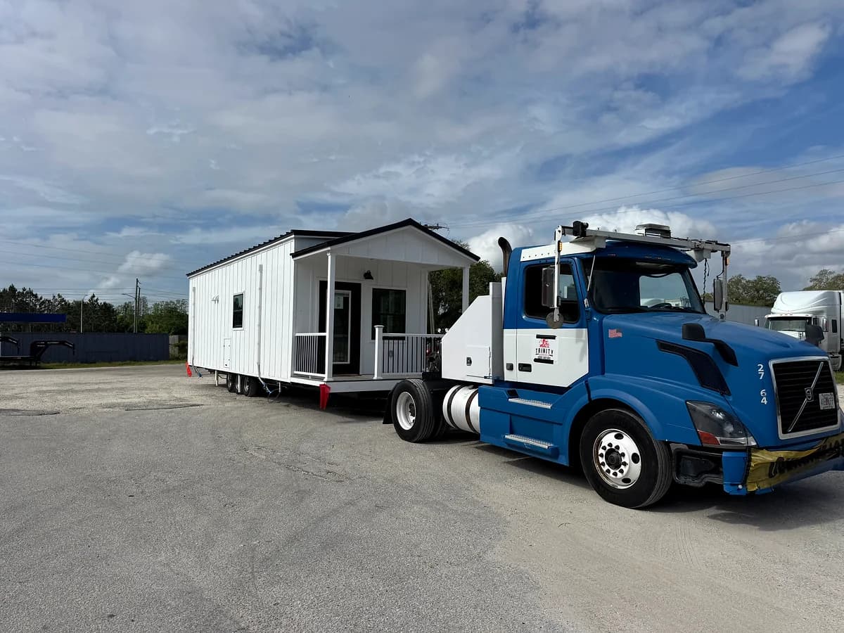 Trinity blue Volvo with a finished mobile home with porch and stairs